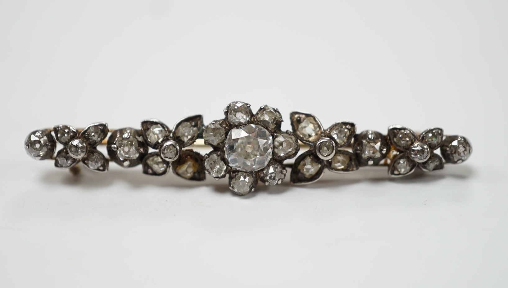 An early 19th century yellow metal and diamond cluster set bar brooch, 47mm, gross weight 4.3 grams. Fair condition.